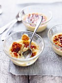 Crème brûlée, half eaten, in glass bowls