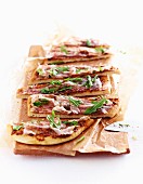Slices of pancetta and rocket pizza