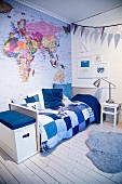 Map of world and patchwork bed cover in child's bedroom in shades of blue
