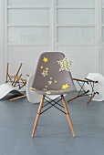 Moderner grauer Stuhl aufgepeppt mit Textilaufklebern in Sternenform