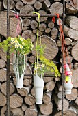 Homemade hanging flower vases made from plastic bottles and string