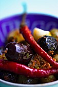 Marinated chillis with olives in a blue bowl