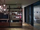 Flatscreen TV on living room shelving, glass bubble pendant lamps n foreground and bedroom reflected in glass wall