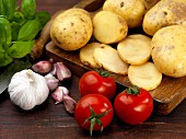 An arrangement of potatoes, tomatoes, garlic and basil