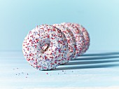 Doughnuts with white icing and colourful sugar sprinkles