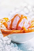 A scoop of strawberry ice cream in a puff pastry dish