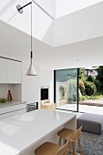 White, modern interior with view of garden