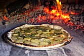 Potato and rosemary pizza baking in a pizza oven