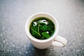 A cup of herb tea on a table