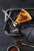 A slice of sweet pumpkin tart with chocolate cream and cocoa powder