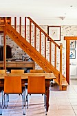 Wooden staircase, stone wall and tiled floor in dining area