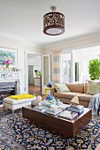 Books on a cube-like coffee table and elegantly patterned oriental carpet in a traditional living room