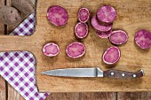 Sliced purple potatoes on a wooden board