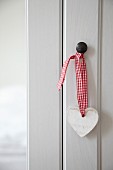 Heart-shaped pendant on cupboard doorknob