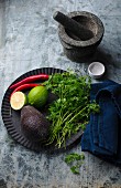 Ingredients for guacamole on a black metal plate