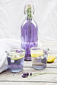 Homemade lavender lemonade in a flip-top bottle and glasses
