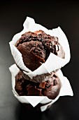 Two chocolate muffins in white paper