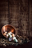 Free range eggs in copper bowl on straw