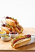 Hot dogs in rolls with gherkins, mustard and relish