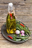 Olive oil with rosemary, garlic and chilli peppers in a bottle on a wooden table