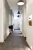 Bicycle on paved floor in narrow hallway with industrial-style pendant lamps