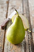 A whole pear and half a pear on a wooden surface