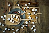 An arrangement of cinnamon star biscuits, wooden spoons, cinnamon sticks and cutters