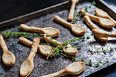 Savoury spoon shaped biscuits with thyme and Parmesan on a baking tray