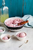 Homemade raspberry ice cream in a bowl and dishes