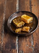 Honeycomb with honey in a brown ceramic dish