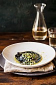 A giant black ravioli in brown butter with cress
