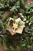 Gift boxes decorated with pine sprigs, pine cones and a star shaped biscuit