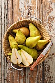 A basket of pears on a rustic wooden table