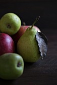 Birnen und Äpfel auf dunklem Holzuntergrund