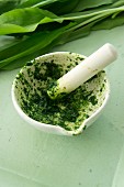 Crushed wild garlic leaves in a mortar