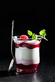 A layered dessert with quark and raspberries in a glass