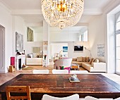 Interior with wooden table, crystal chandelier & seating area in modernised, Wilhelmine-era building