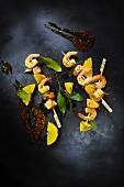 Barbecued salmon, prawn and orange skewers (seen from above)