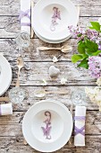 Spring dining table festively set with bouquet of lilac & butterfly ornaments