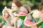 Kinder essen genussvoll Wassermelone im Freien