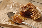A wild bee honeycomb on parchment paper and a spoon
