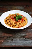 Spaghetti with fresh tomatoes on an old wooden table