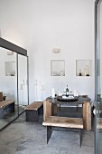 Rustic benches and dining table made from wood and metal next to mirrored elements