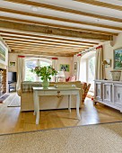 Konsolentisch an Sofa in ländlichem Wohnzimmer mit Holzbalkendecke und elegantem Flair