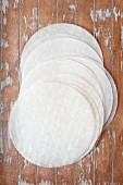 Round sheets of rice paper on a wooden surface