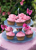 Cupcakes with rose cream on a cake stand on a garden table