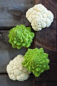 White cauliflower and Romanesco broccoli on a wooden crate