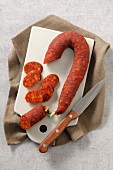 Spanish chorizo with a knife on a chopping board