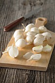 White onions on a wooden chopping board