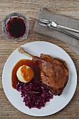 Leg of goose with red cabbage, dumplings and demi glace (seen from above)